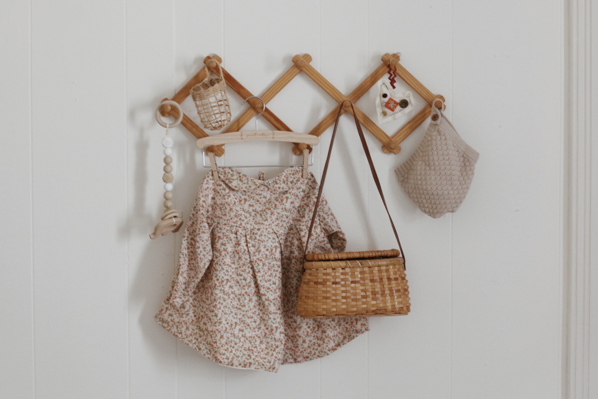 accordion wall rack with baby items hanging on it