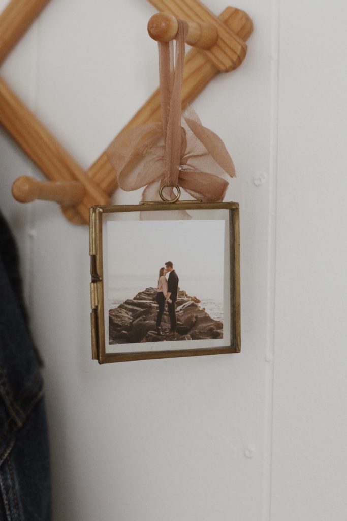 gold frame with photo of man and woman kissing hanging on wood rack