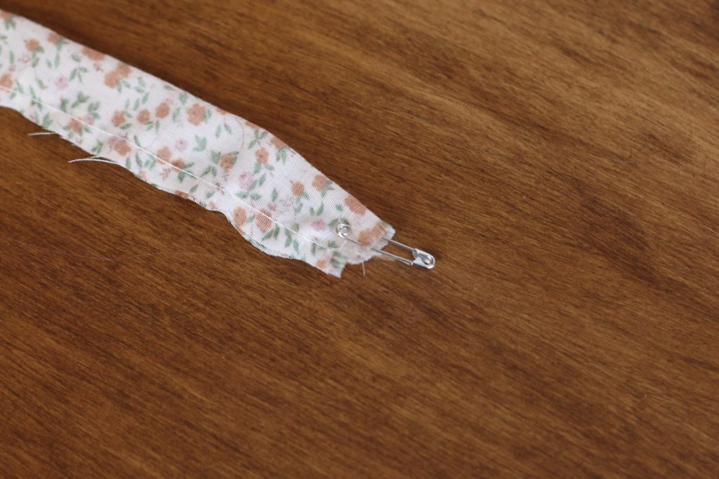 safety pin attached to fabric on wood table