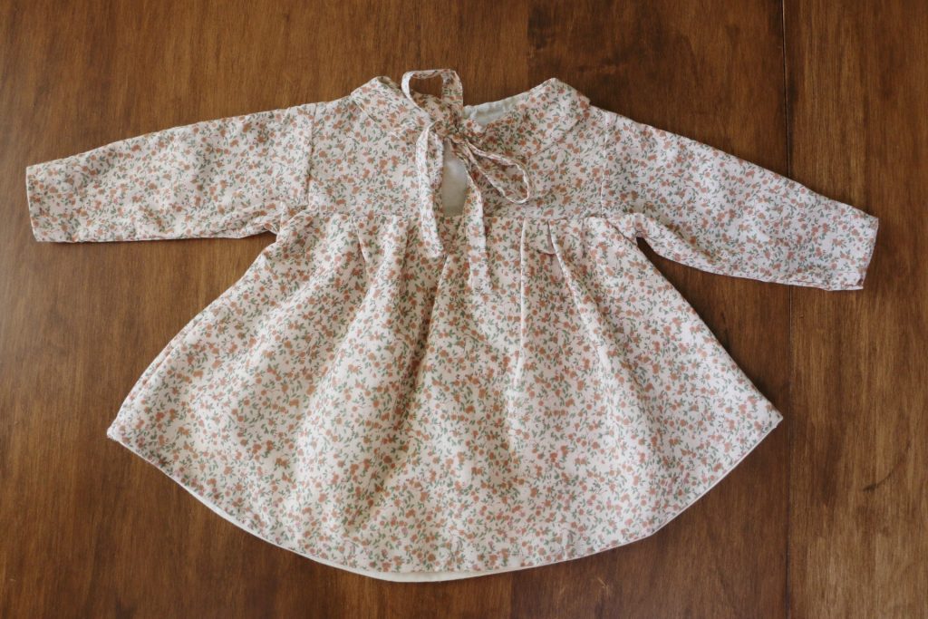 back of baby dress on wood table