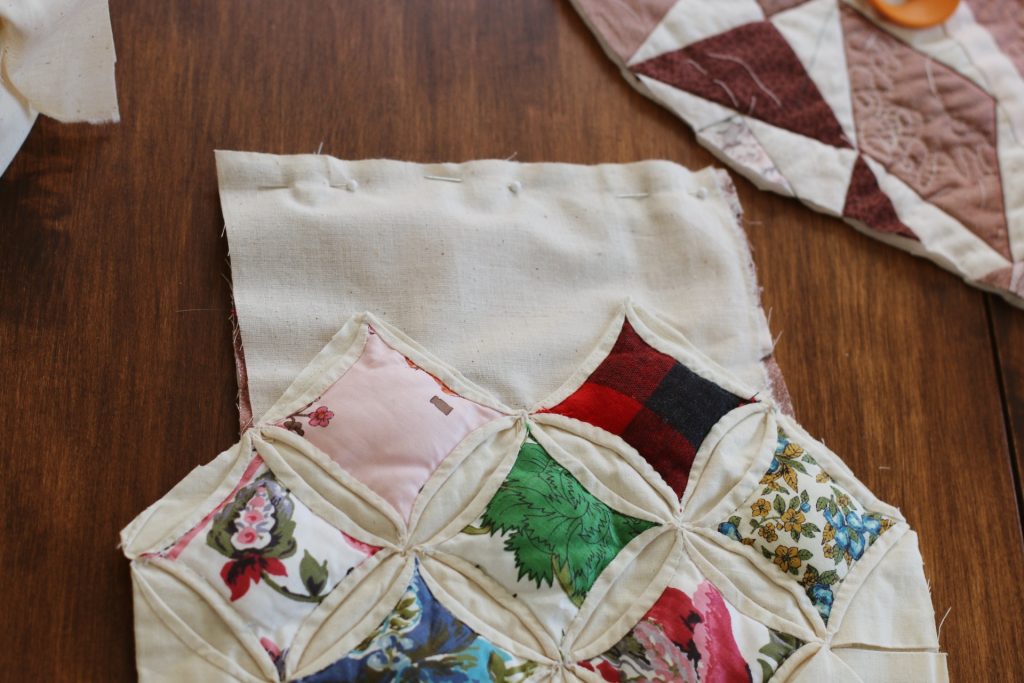 quilt scraps pinned together to sew on wood table