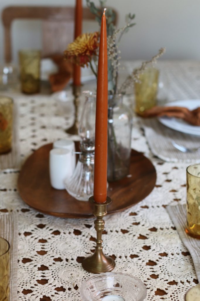 rust table in brass candlestick with thanksgiving table setting 