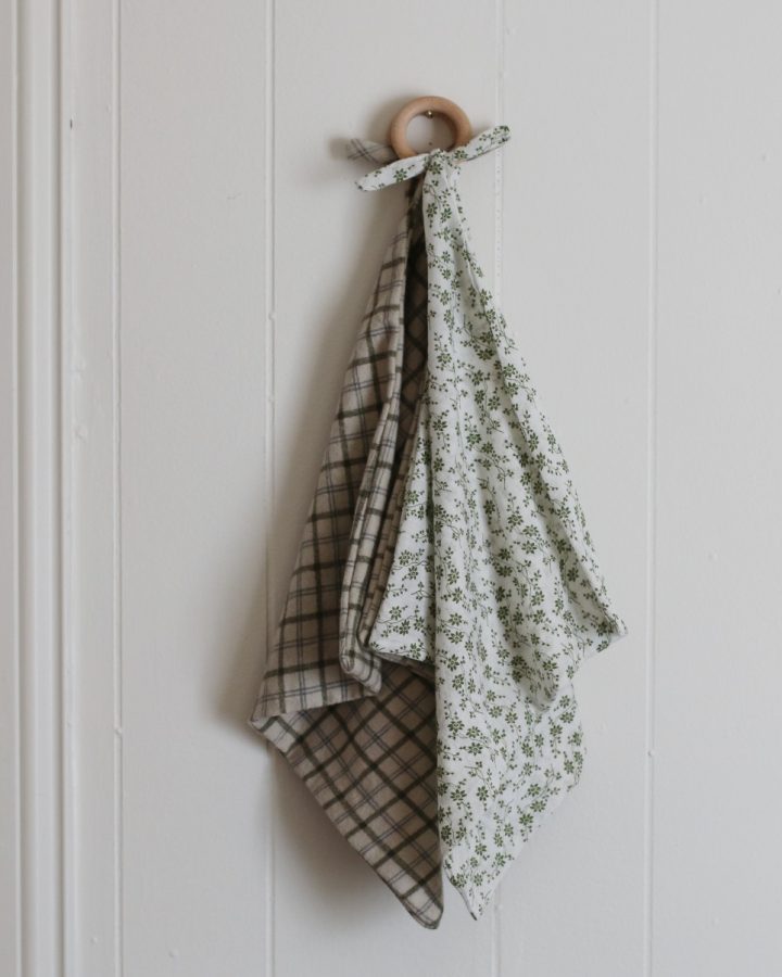 teether baby blankets hanging on white wall