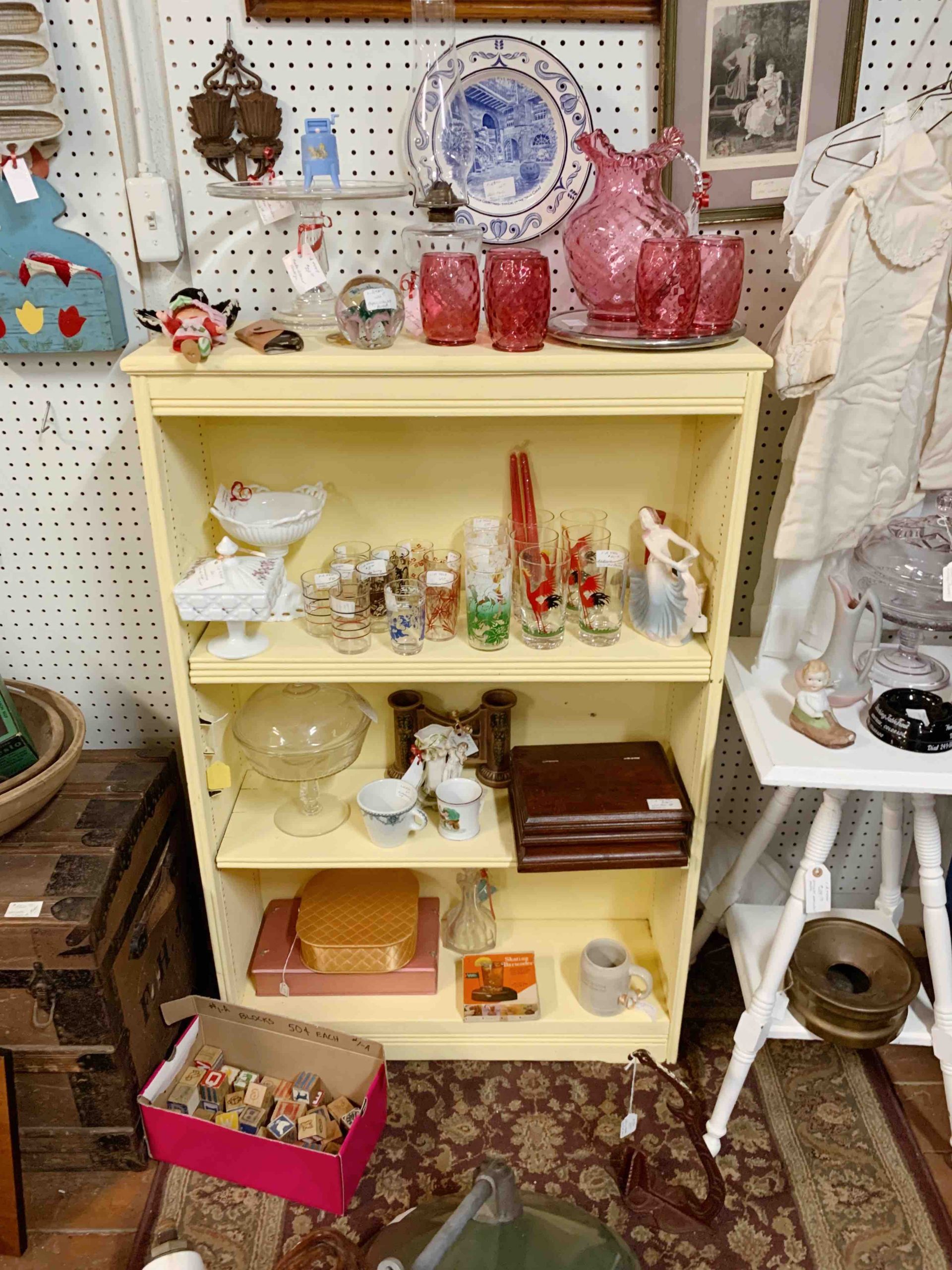 yellow bookshelf displaying antiques