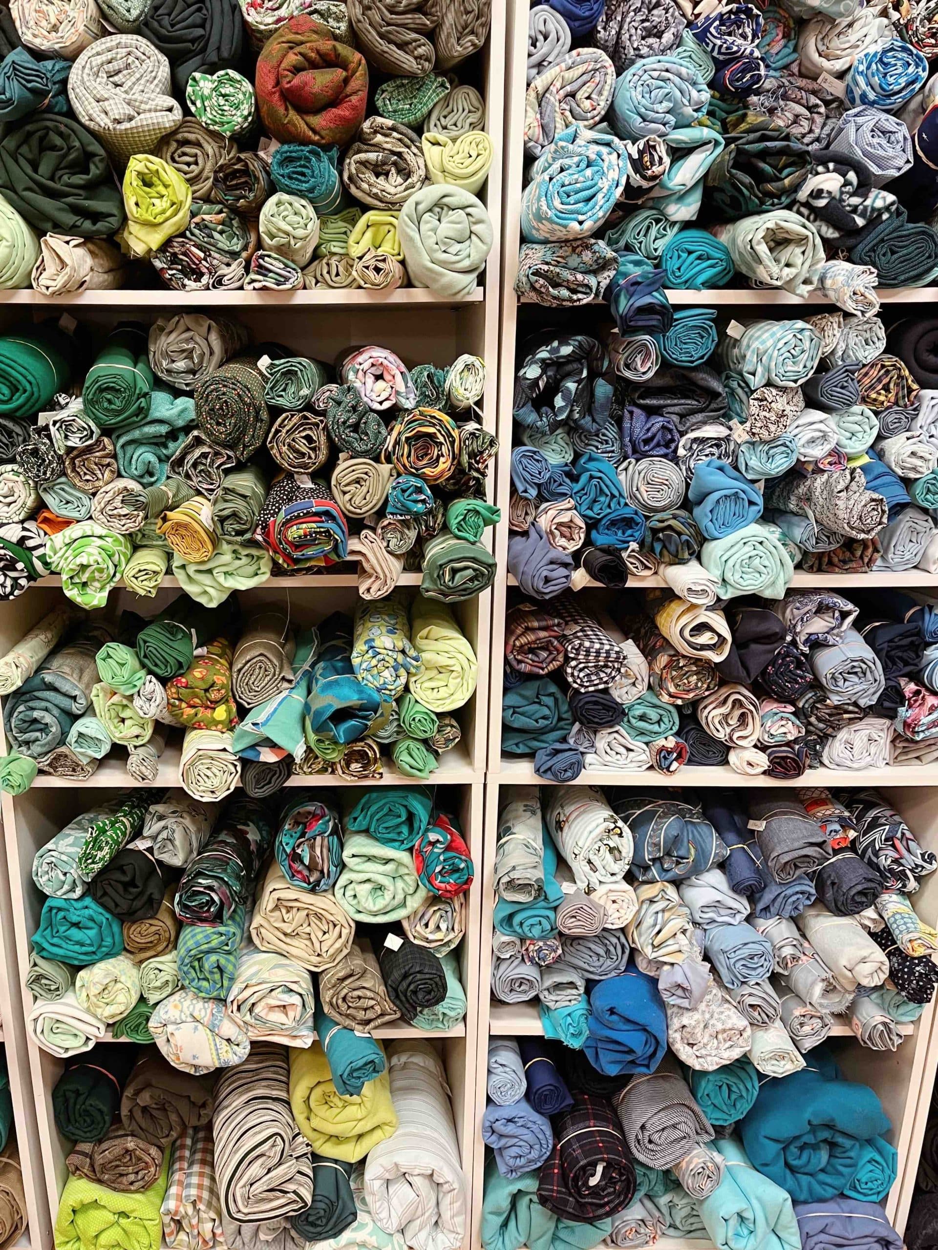 fabric scraps rolled up on display wall in thrift store