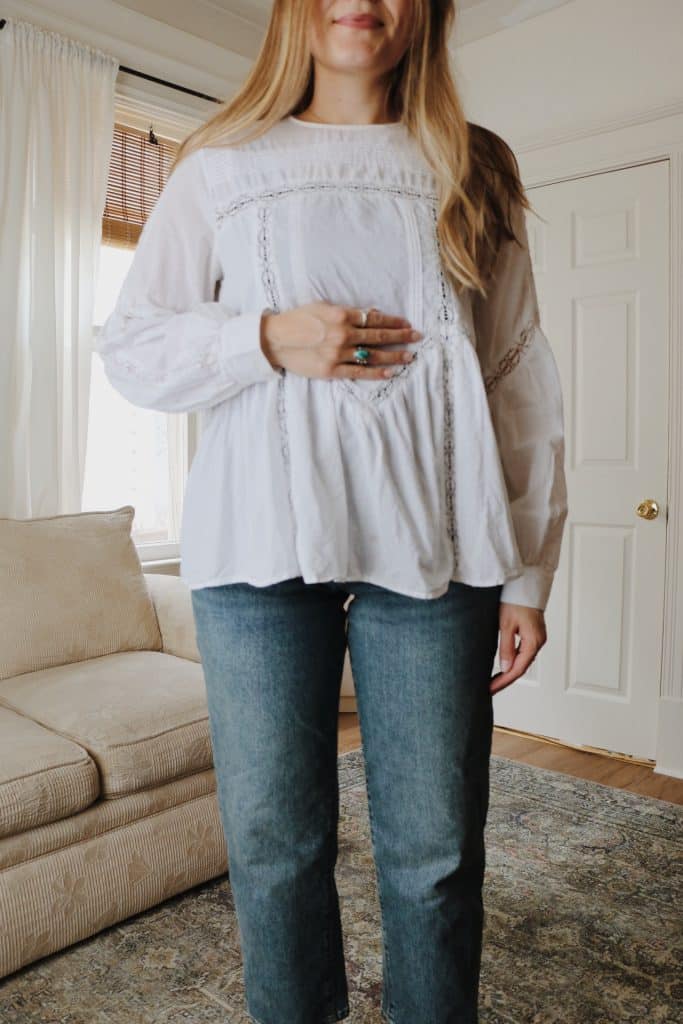 pregnant woman wearing white blouse and denim jeans