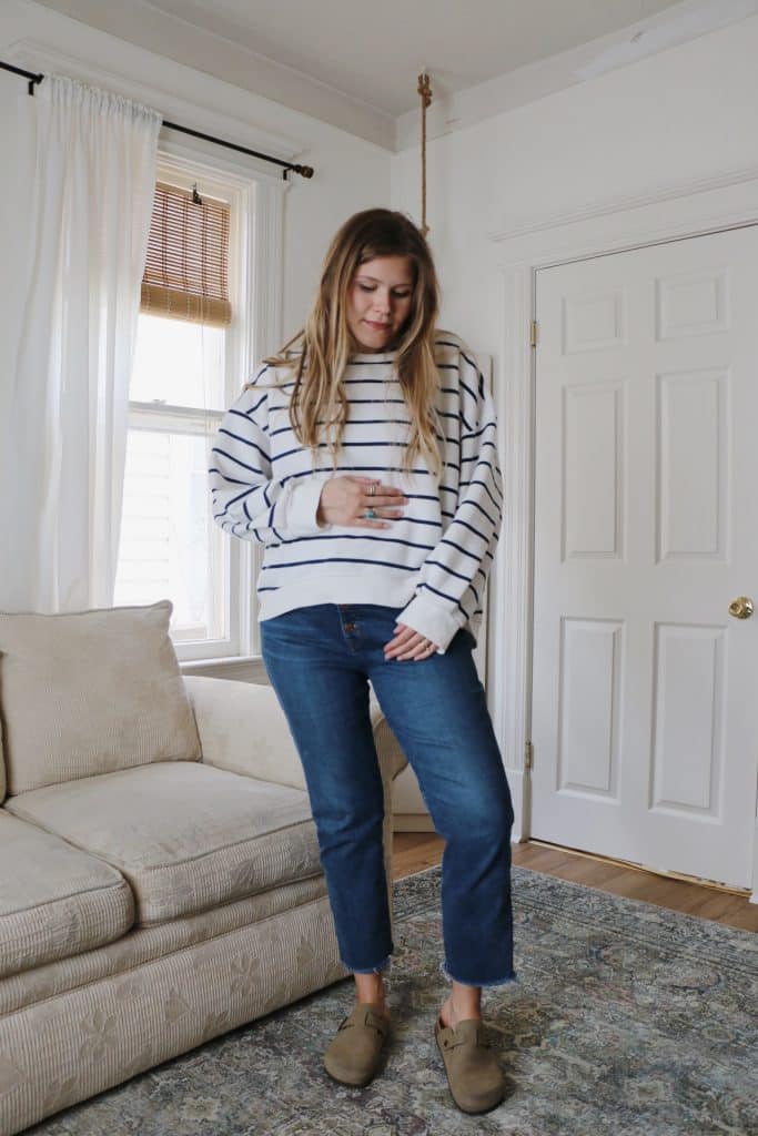 pregnant woman wearing striped sweatshirt and jeans