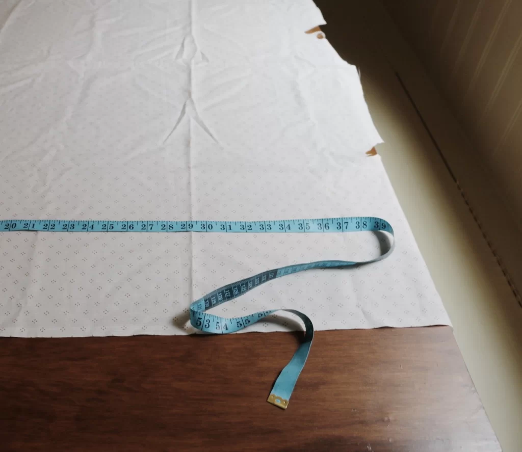 measuring tape on fabric on wood table